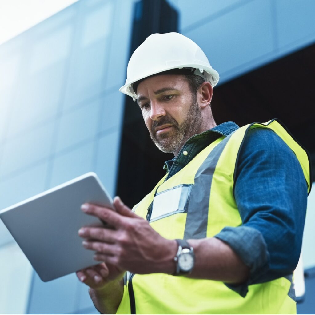 Man at construction site looking at tablet