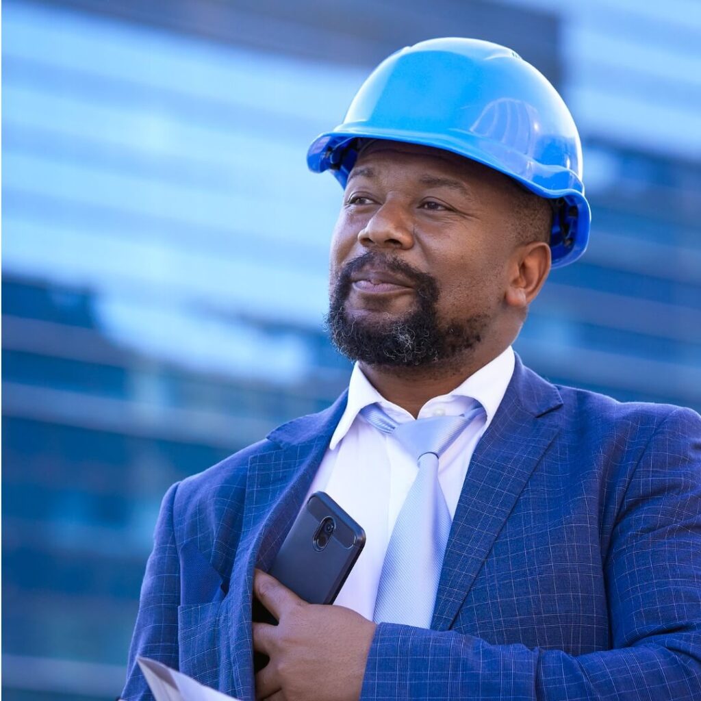 man in hardhat putting his cell phone away after a call