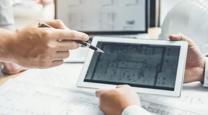 Two people looking at a project drawing on a tablet