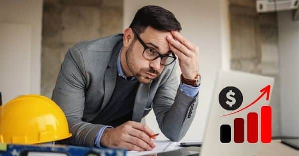 man sitting at computer frustrated, indicating the screen is showing increased prices for software